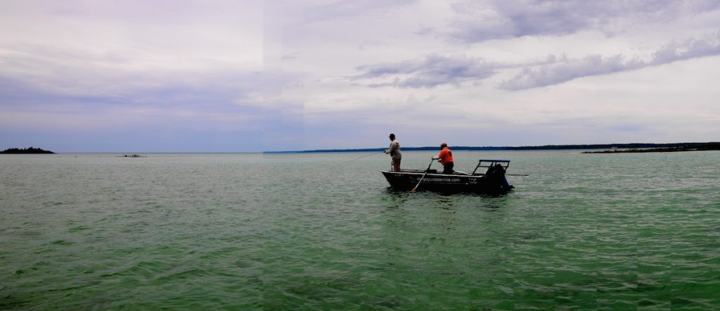 Guide Steve Martinez pushes Cameron Mortenson across a Great Lakes flat.